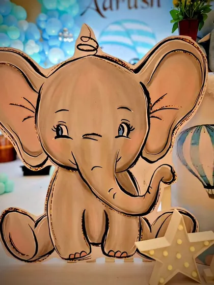 A hand-drawn style elephant cutout adds a charming and artistic touch to this birthday setup.