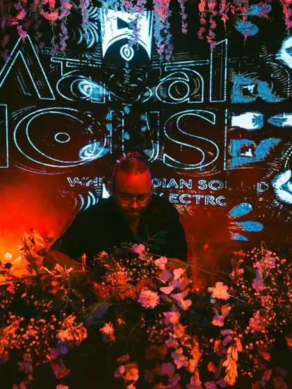 Behind a wall of flowers at the launch of my Masala House event series. This concept blends Indian ethnic sounds with electronic music, creating a unique, vibrant atmosphere.