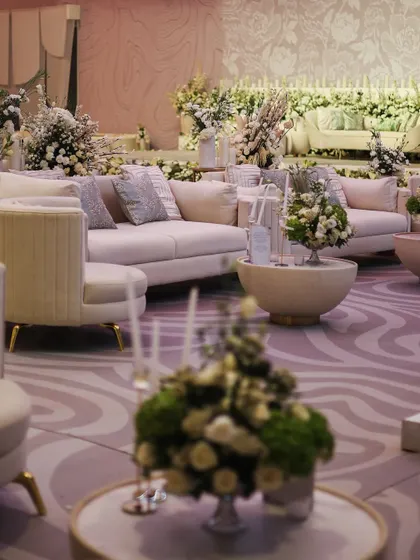 The lounge areas were designed with plush, off-white sofas and elegant floral arrangements, creating a sophisticated and comfortable space for guests.