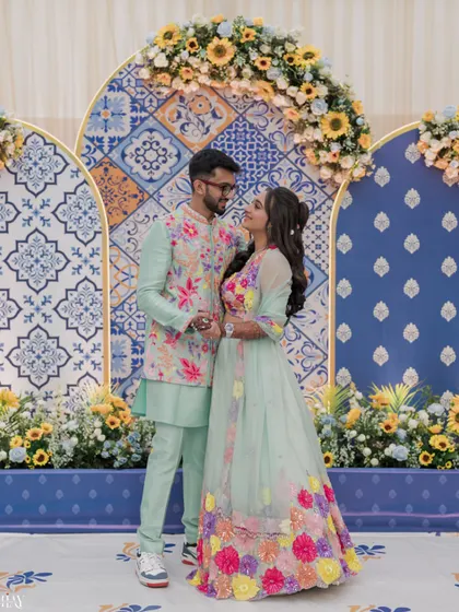 A classic portrait of the couple in their pastel outfits against a beautiful Moroccan-themed backdrop.