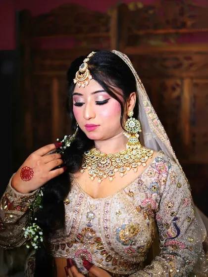 A detailed shot of the bridal makeup and jewelry paired with our pastel lehenga. We can help you envision the complete look.