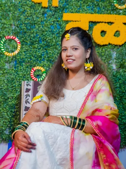 A beautiful portrait of the bride-to-be at her Haldi ceremony, dressed in white and adorned with floral jewelry.
