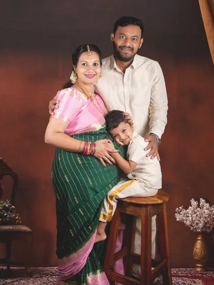 A traditional maternity photoshoot where the family is dressed in beautiful Indian attire. The rich colors and warm lighting create a classic and heartfelt portrait.
