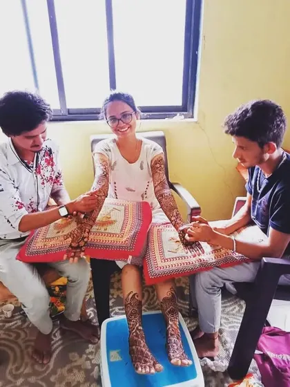 Here I am with my team, applying full bridal mehendi for a client at her home. We ensure the bride is comfortable while we create her dream design on her hands and feet.
