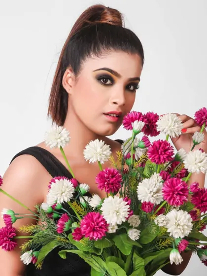 Incorporating props like flowers can add a soft and fresh element to a beauty shot. This portrait with dramatic smokey eye makeup and a bouquet of flowers creates a beautiful contrast.