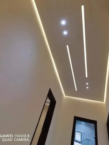 A minimalist hallway ceiling featuring clean, straight lines of profile lighting. This creates a sleek, modern, and well-lit path through the home.