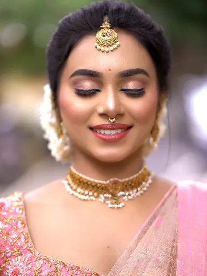 A peaceful moment captured. The soft eye makeup and gentle smile create a look of serene beauty.