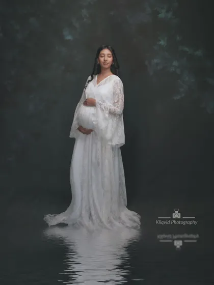 Celebrate the serene beauty of motherhood. This portrait in a white lace gown with a water reflection effect is a precious, beautiful memory.