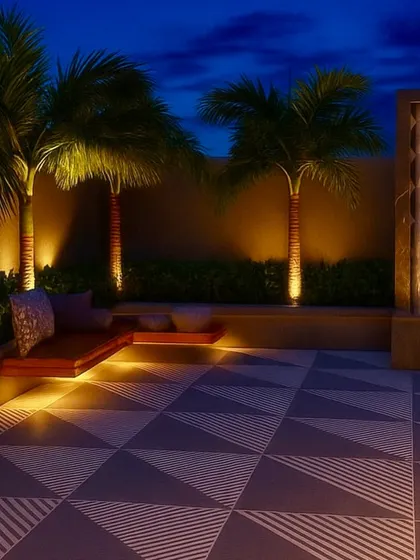 The Kirti Nagar terrace concept at night, with uplighting on the palms and the waterfall creating a luxurious and dramatic effect.