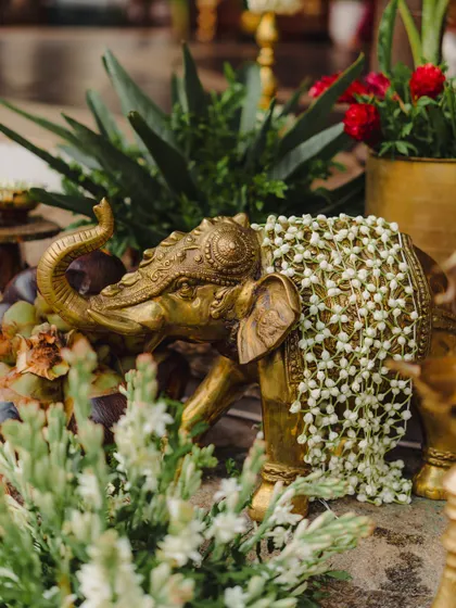 A brass elephant statue adorned with a delicate net of jasmine flowers. These small, thoughtful details are what elevate a decor setup from beautiful to unforgettable.