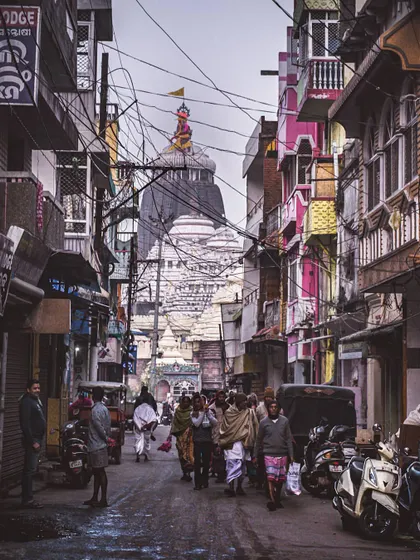 a temple visible at the end of a busy street in puri. this photo is about leading the eye towards a central point of interest, a fundamental part of user navigation design.