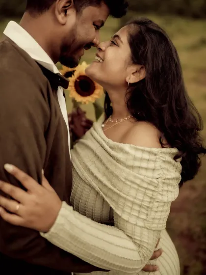 An intimate close-up of the couple, nose-to-nose and sharing a smile. The sunflower adds a pop of color to this tender, romantic portrait.
