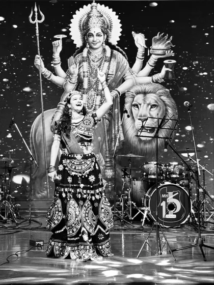 A powerful black and white shot from a Navratri event, capturing the divine energy of the festival on stage.