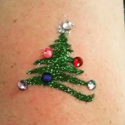 A classic Christmas tree design in green glitter, decorated with colorful gems for extra sparkle. This is a fun and festive option for holiday carnivals and events.