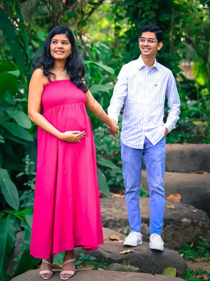 A simple and sweet portrait of an expecting couple. The pop of pink from the mother-to-be's dress and their relaxed poses make this a lovely, casual maternity photo.
