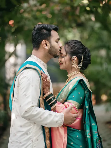 A tender forehead kiss, a gesture of love and protection. This intimate portrait highlights the couple's bond and the beautiful details of their traditional attire.