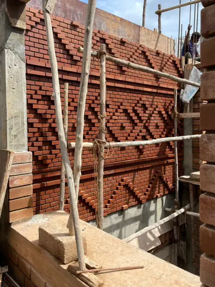 The complex, protruding brick pattern catches the light in interesting ways, creating a dynamic surface that changes throughout the day.