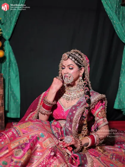 A seated pose of the Rajasthani bride, giving a clear view of the intricate hair jewelry and the classic bridal braid.