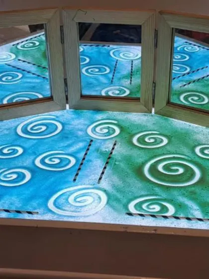 A light table with colored sand and mirrors creates a mesmerizing canvas for mark-making. The reflection and light add a magical dimension, encouraging children to explore patterns, shapes, and symmetry.