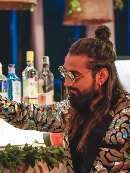 Mixing beats and drinks. My flashy jacket and focused expression show my dual role as both a performer and a master mixologist.