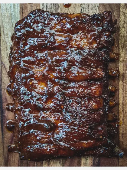 A close-up of my Barbeque Pork Ribs, showing the glistening, caramelized homemade sauce coating the entire rack.