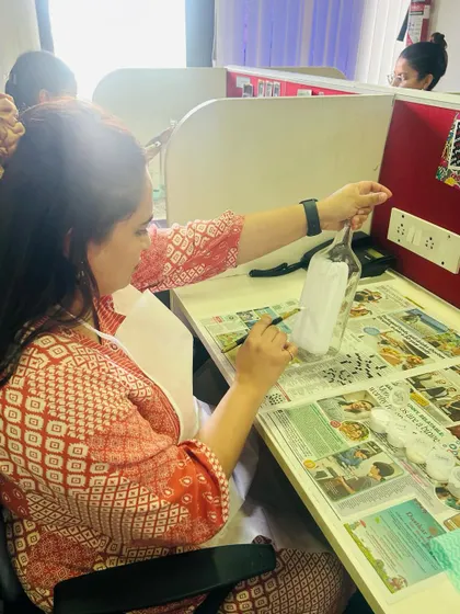 A participant carefully applying details to her decoupage bottle. This craft requires focus and patience, making it a wonderfully mindful activity.
