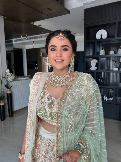 A portrait showing the complete look, with a modern maang tikka and soft, glowing makeup.