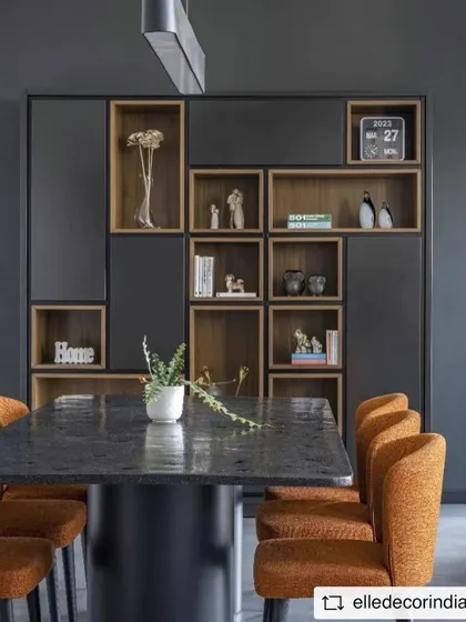 The dining area features a custom-designed table and a bespoke shelving unit. The open-backed shelves provide display space without adding visual weight, maintaining the room's airy and minimalist feel.