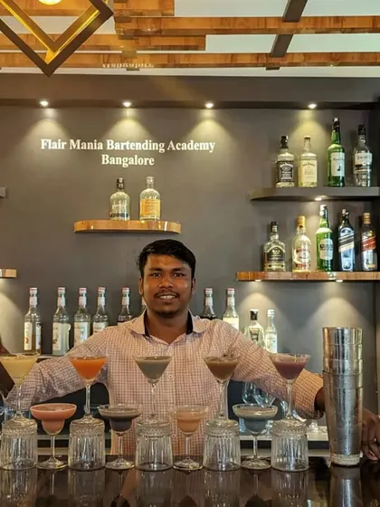 A student from our Bangalore branch stands proudly behind a lineup of cocktails he has prepared.