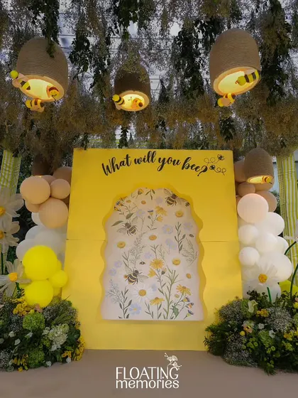 The main photo backdrop was a highlight of the event. A bright yellow wall with the question 'What will you bee?' featured a beautiful floral insert, framed by balloons, daisies, and hanging handmade beehives.