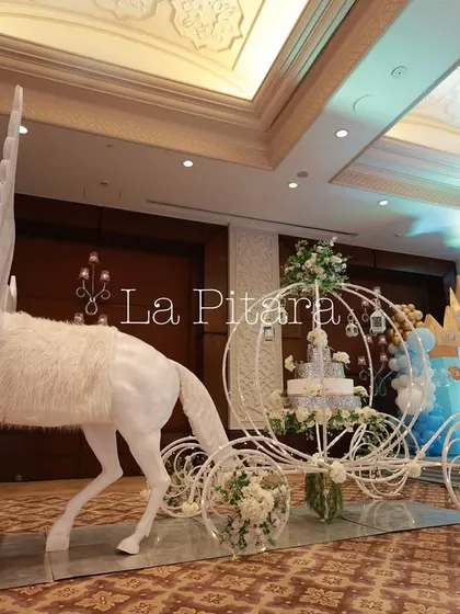 A fairytale-worthy installation of a white horse pulling a Cinderella-style carriage. This magnificent prop, adorned with white flowers, was a showstopper and a perfect photo spot for the little prince's party.