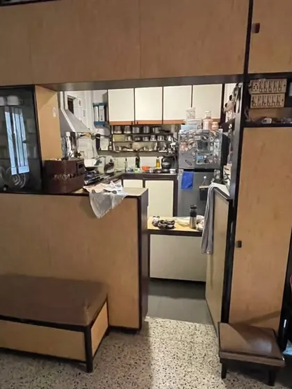 **BEFORE:** The original layout featured a bulky, built-in credenza and bar that separated the kitchen from the living area, creating a visual barrier.