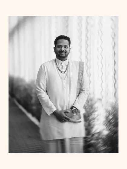 A stylish black and white portrait of the groom in his traditional wedding attire, with a creative motion blur effect.