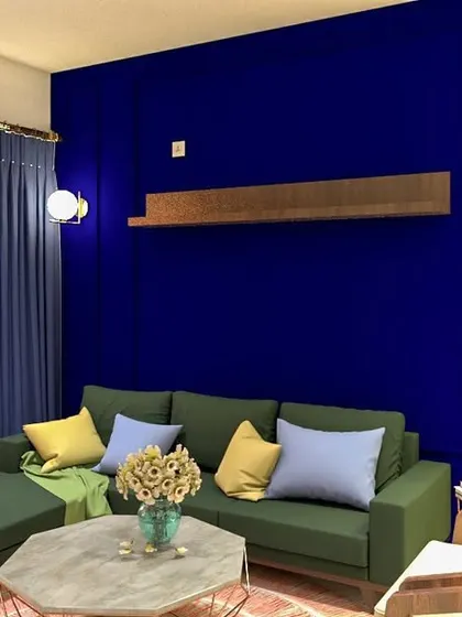 A cozy living room setup with a green L-shaped sofa against a vibrant blue wall. The mix of colors and textures creates a comfortable and visually interesting space.
