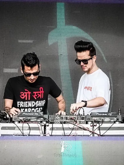 Focused and in sync during a collaborative DJ set. Two DJs working together means we can layer sounds and create transitions that wouldn't be possible alone.
