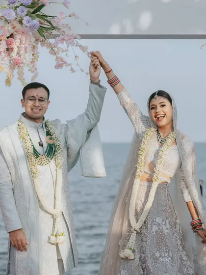 Just married, with the ocean behind them! This joyful shot captures the couple's happiness at their beautiful beachside mandap in Thailand.