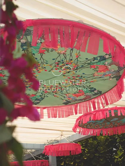 Custom-printed fabric with a fringe detail is used as a hanging decoration, part of the layered ceiling treatment.