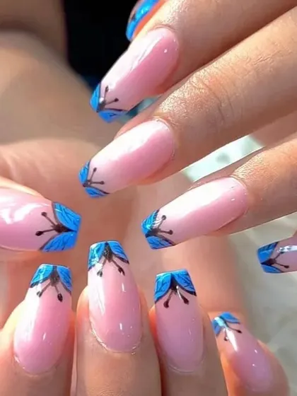 A full view of the creative and artistic butterfly wing nail art on long coffin extensions.