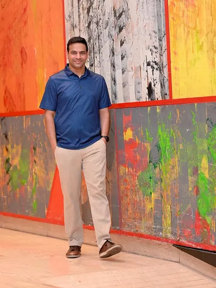 A relaxed, full-length portrait against a colorful, artistic wall. This shows a creative and modern personality, helping a profile stand out.