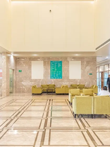 Another view of the Fortis Hospital lobby highlights the successful integration of healthcare functions within a former hospitality space. The design balances clinical requirements with a warm, inviting atmosphere, proving that adaptive reuse can create superior patient environments.