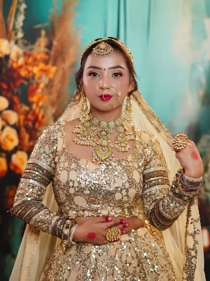 A front-facing portrait showcasing a magnificent bridal look. The heavy necklace, earrings, and nose ring are perfectly balanced with the makeup and hairstyle.