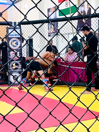 A glimpse into the grappling exchange during a competitive MMA match. Our fighter works to take his opponent down against the cage wall, showcasing the wrestling aspect of our training.