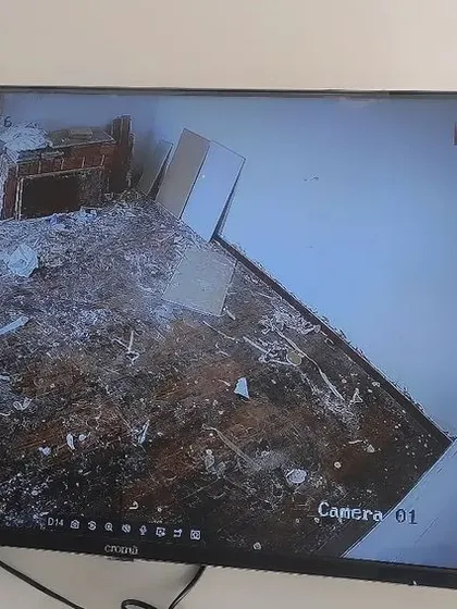 This camera is monitoring a room during renovation or cleaning. The feed is clear enough to see the details on the floor.