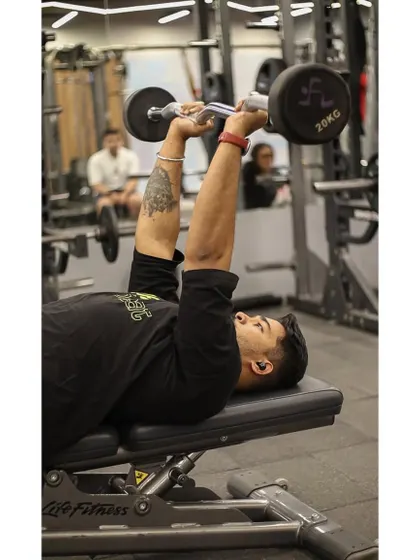 The skull crusher, or lying tricep extension, is a powerful exercise for building arm strength, demonstrated here with an EZ curl bar.