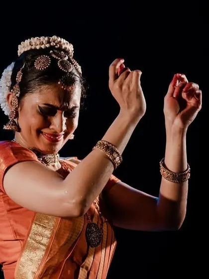 An expressive moment from "SARVASYA," where the hands and face convey the depth of the poetry.