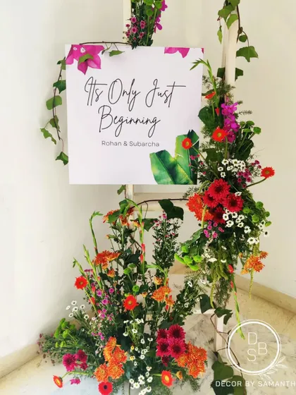 It's only just beginning. A beautiful welcome sign adorned with fresh, vibrant flowers, with me adding the final touches. This is the kind of personal detail I love to create.