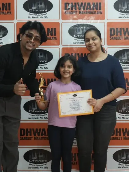 A teacher gives a thumbs-up next to his student, who is happy to receive her award. The bond between our teachers and students is one of mentorship and encouragement.