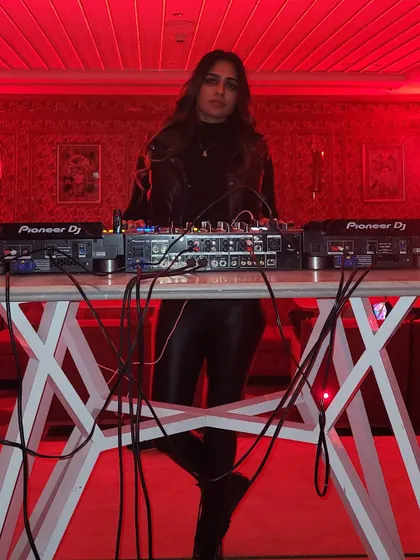 A powerful stance behind the decks in a red-lit room. This photo exudes confidence and control, showing that I am in command of the night's musical journey.