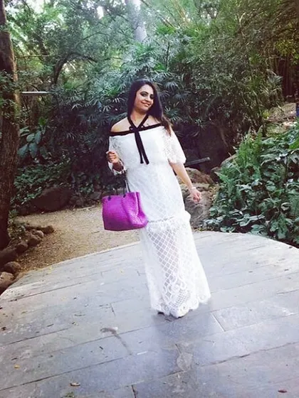 A client enjoying her day in a custom white lace off-shoulder maxi dress. The delicate fabric and elegant silhouette make this a versatile piece for a brunch or a vacation.