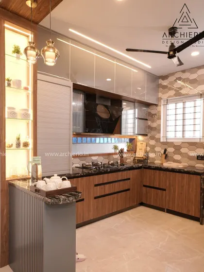 A kitchen that combines wood-finish cabinets with modern grey tones. The hexagonal tile backsplash and open breakfast counter create a stylish and functional space.